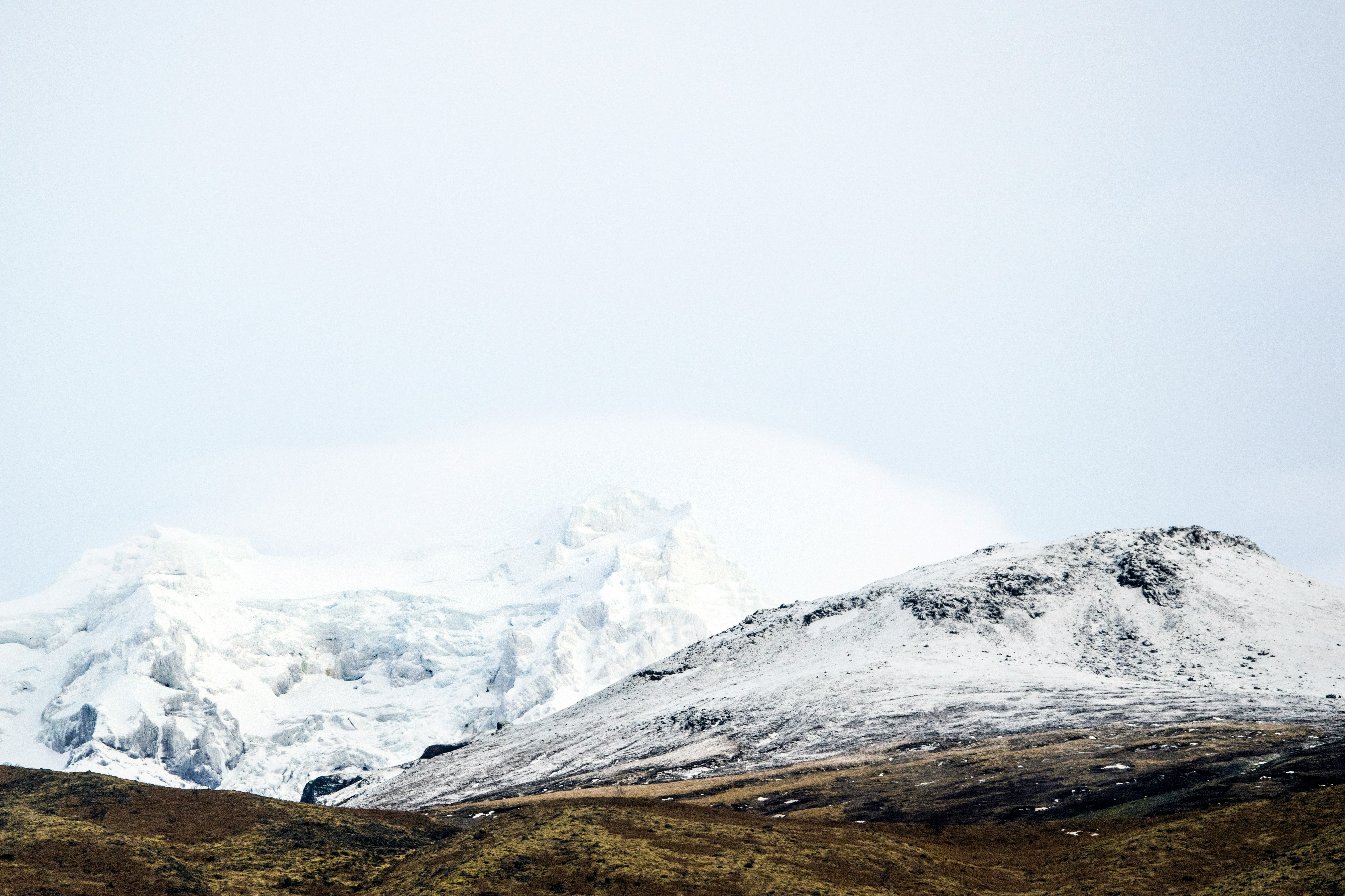 snow covered mountain under white sky during daytime